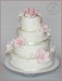 Svatební dort v krémové barvě s krajkou, růžemi a fréziemi
